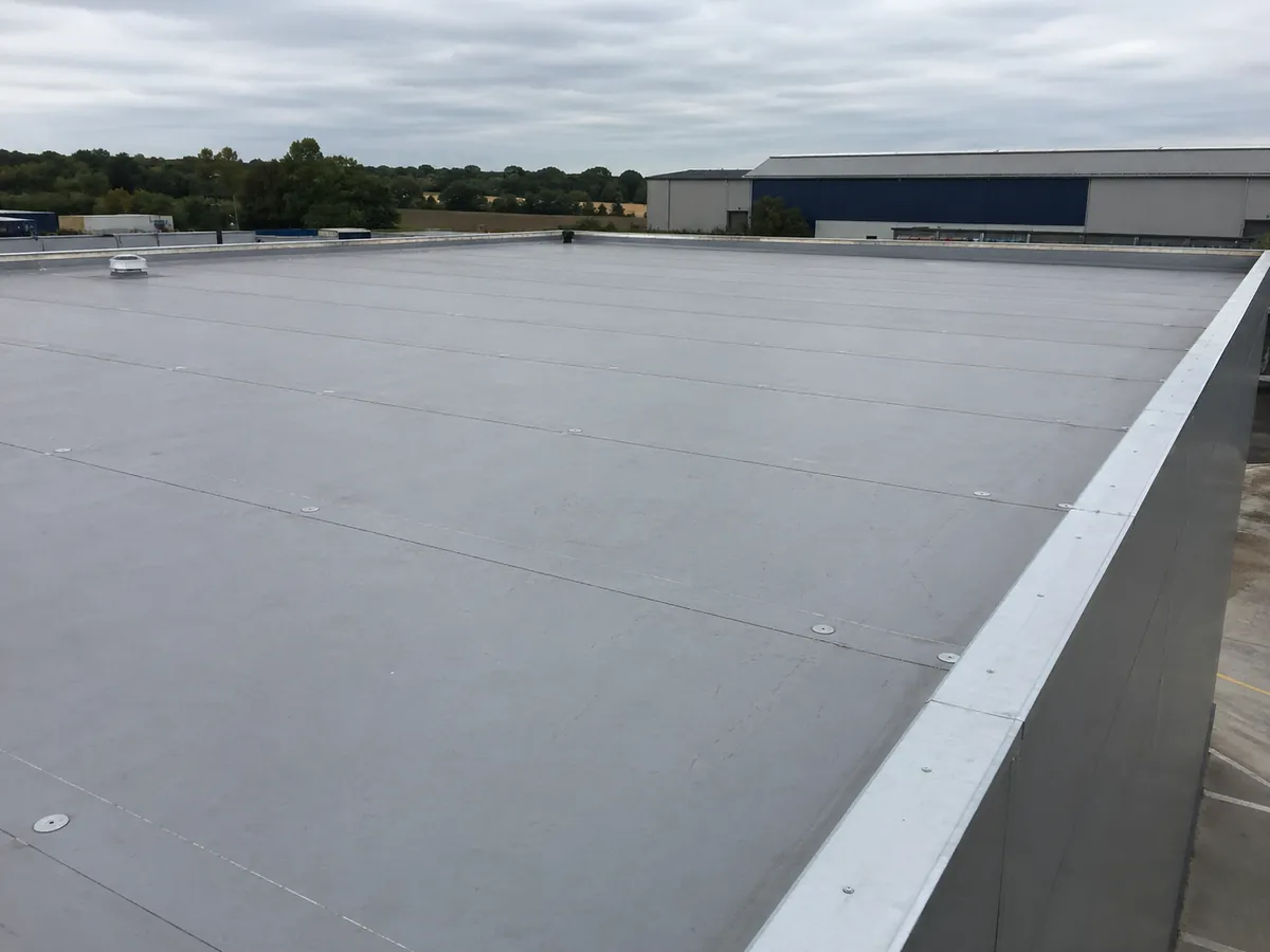 Large grey single-ply membrane flat roof on a Suffolk commercial unit